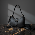 Bolsa hobo preta com fivela dourada em ambiente chic escuro
