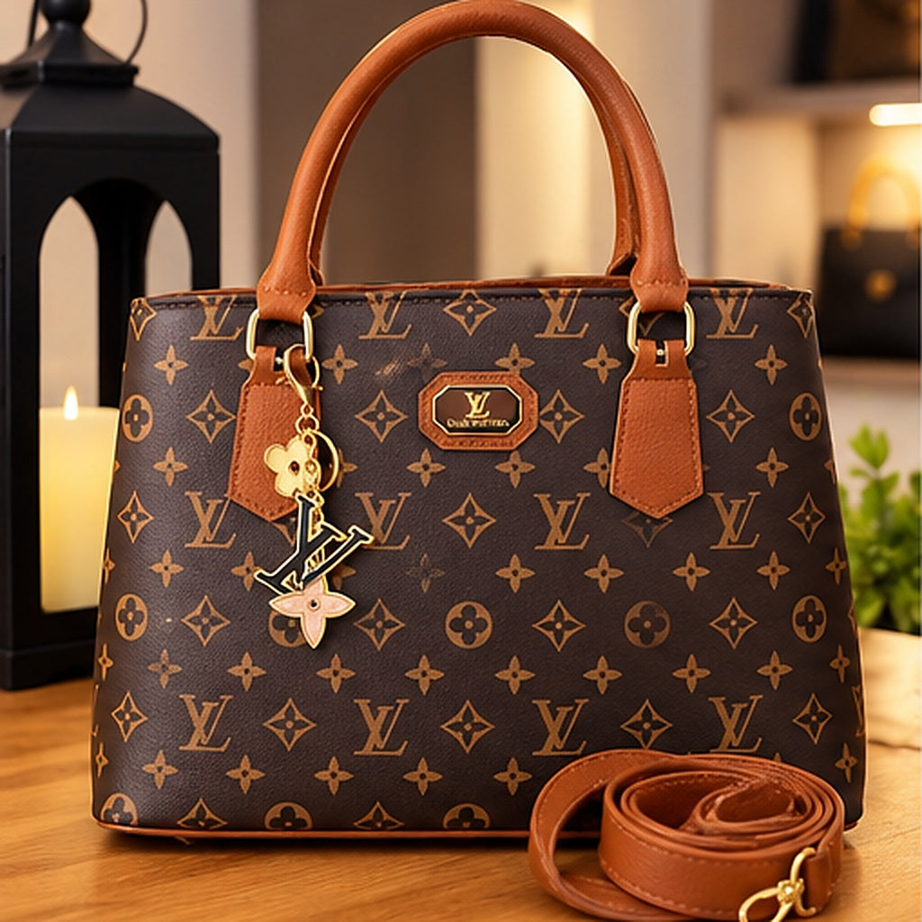 Bolsa tote monograma marrom com acabamento caramelo, alças curtas, pingente dourado e alça longa removível