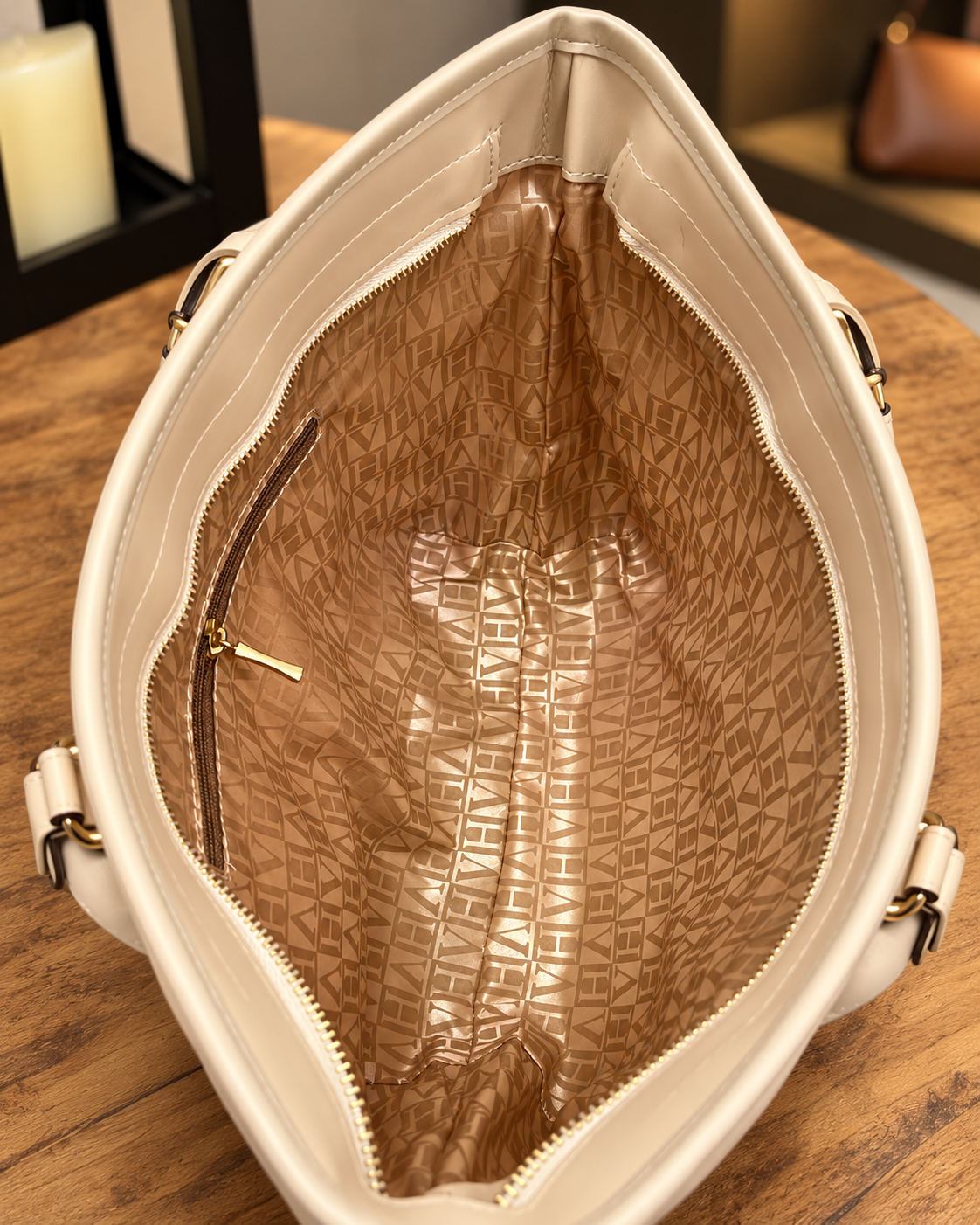 Interior da bolsa com acabamento bege e bolso de zíper